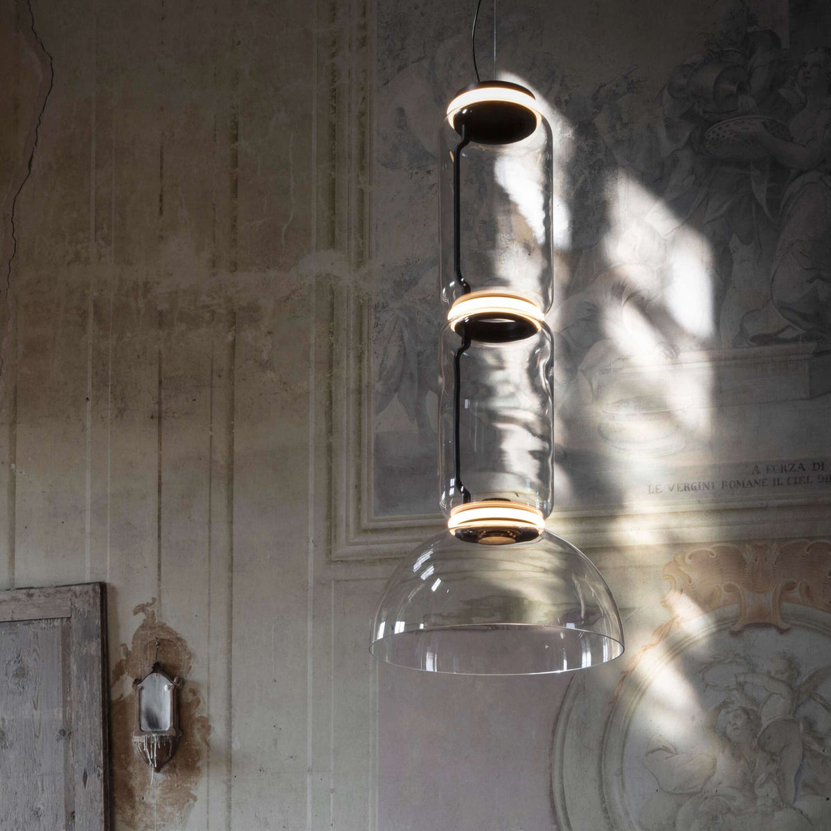 Close view of this Clérachic pendant's dome-shaped shade catching light against a frescoed wall.