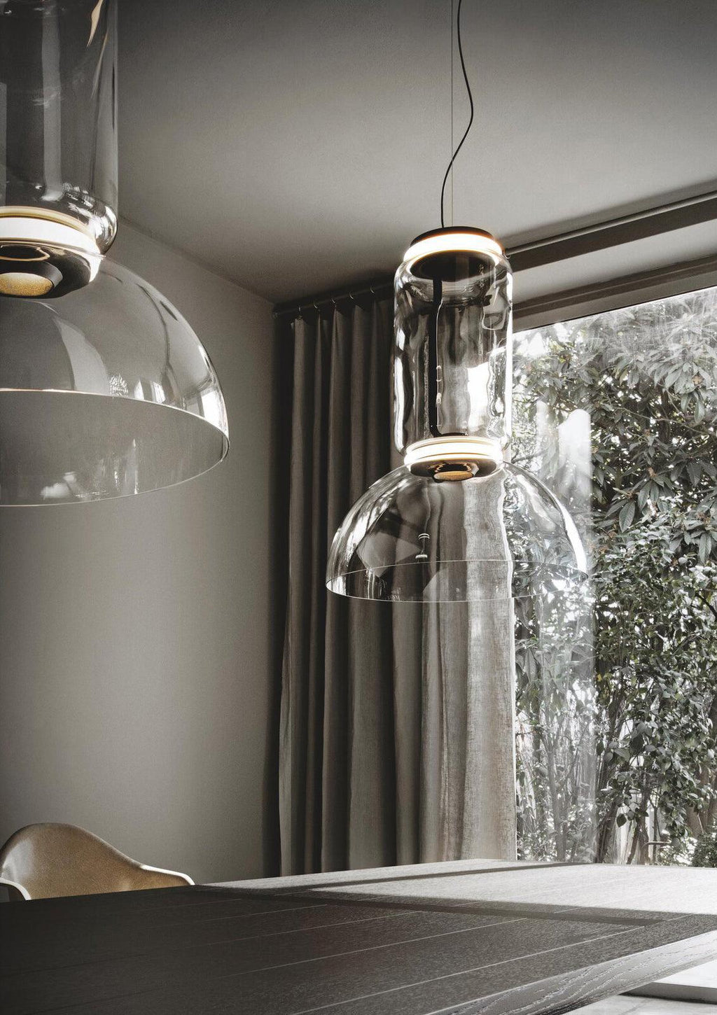 Close view of two dome-shaped Clérachic pendants side by side near a curtained window.