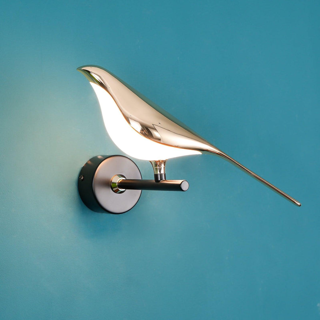 Black and rose gold Nomi bird wall lamp casting soft light