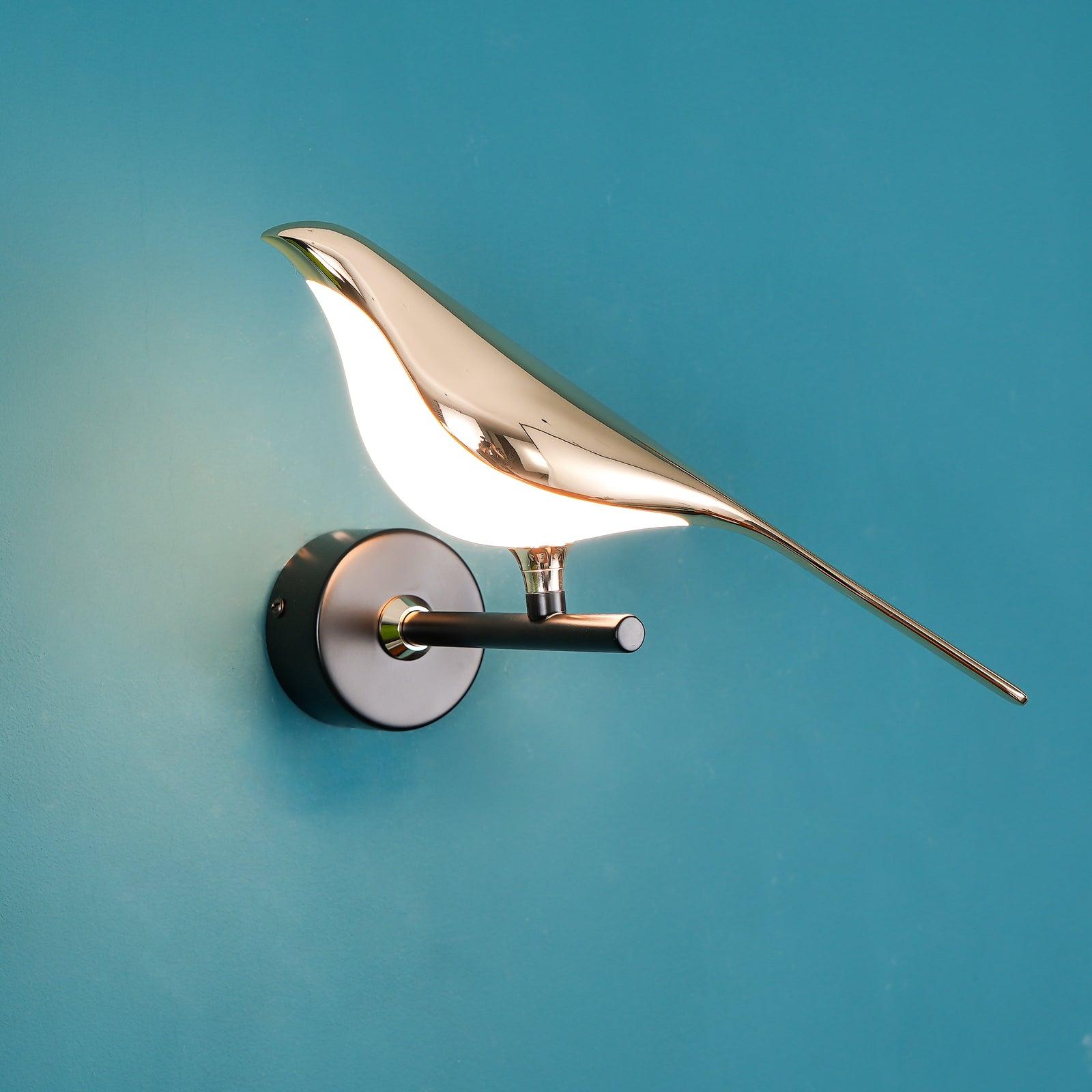 Black and rose gold Nomi bird wall lamp casting soft light