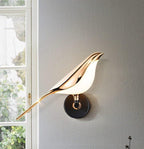 Bird-shaped Nomi wall lamp lighting a cozy interior corner