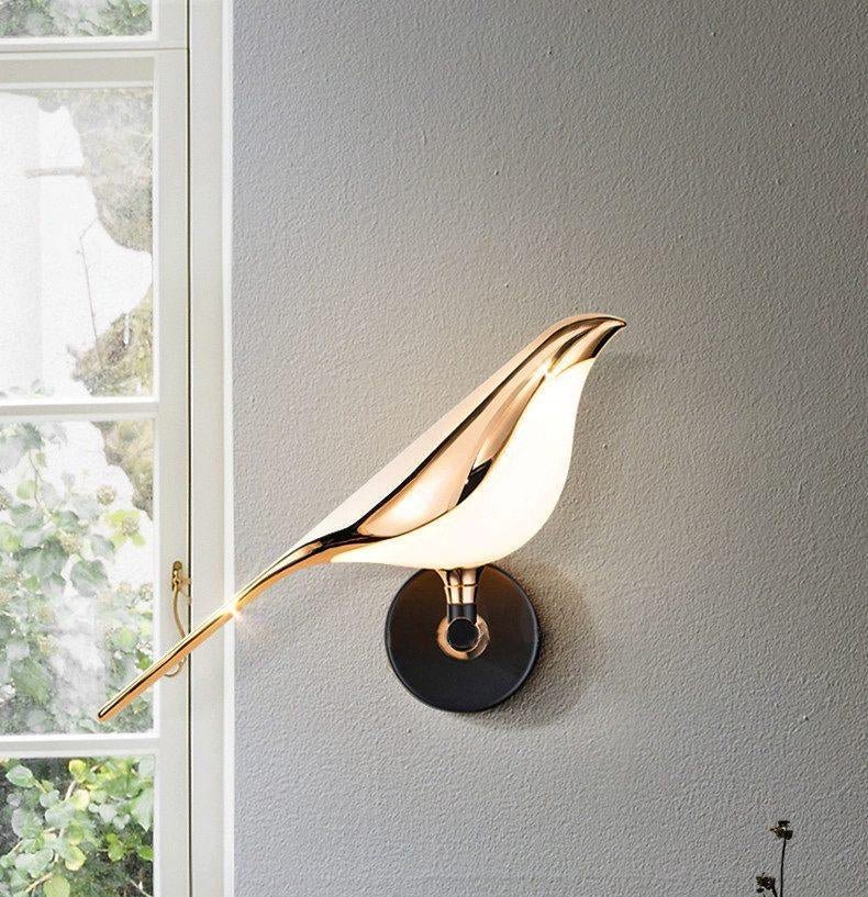 Bird-shaped Nomi wall lamp lighting a cozy interior corner