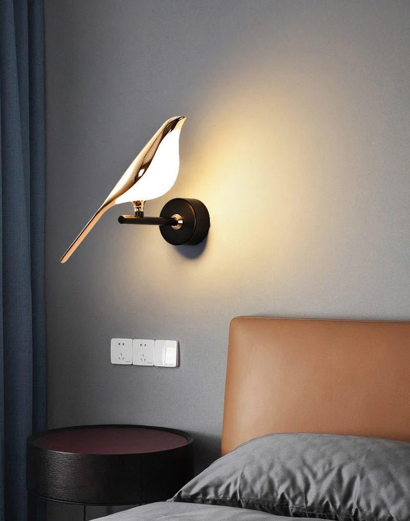 Black and rose gold Nomi bird wall lamp styled in a living room
