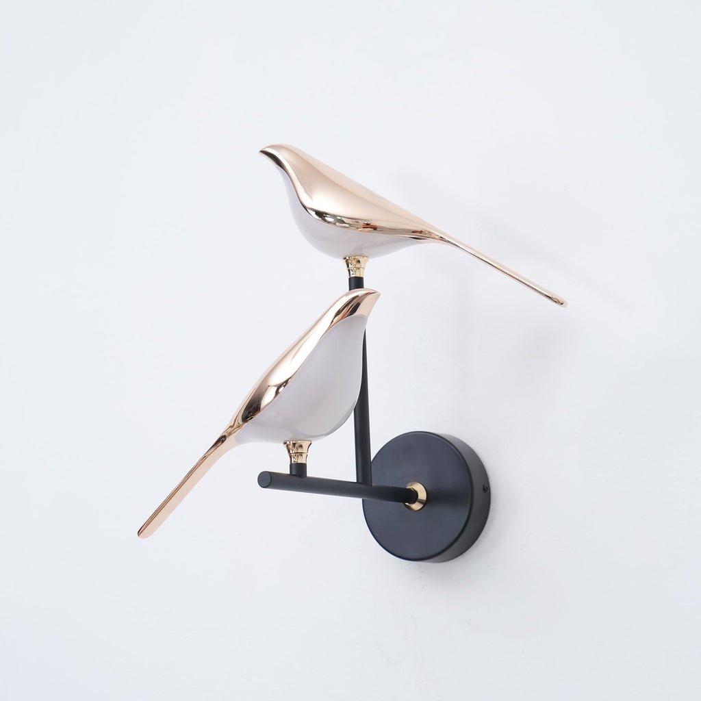Bird-shaped Nomi wall lamp lighting a quiet reading corner