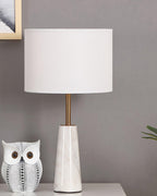Clérachic lamp beside the same ceramic owl figurine, photographed in daylight against a grey wall.