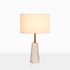 Clérachic lamp with its drum shade glowing warm, cropped closer against a soft grey studio gradient.