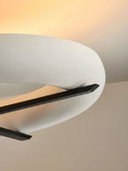 Close-up of the tapered black stem tip on this Clérachic ceiling light, set against its warm-lit white shade.
