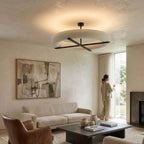 In a warm living room with a leather armchair and abstract art, this black-framed Clérachic ceiling light glows above.