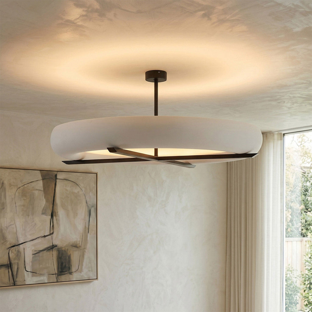 In a room with textured plaster walls and framed sketches, this Clérachic ceiling light in black lights the space above.
