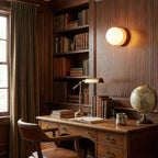 Nuvol compact glass sconce shown beside a bed for reading light