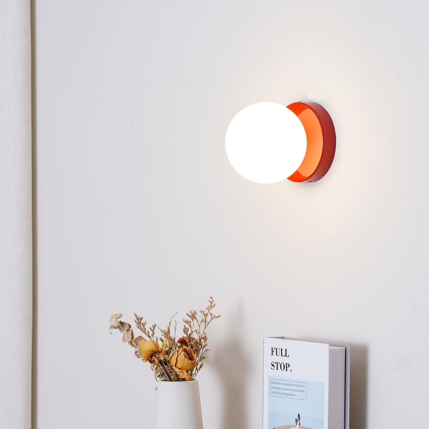 Nuvol wall lamp shown lit at night for a warm ambient glow