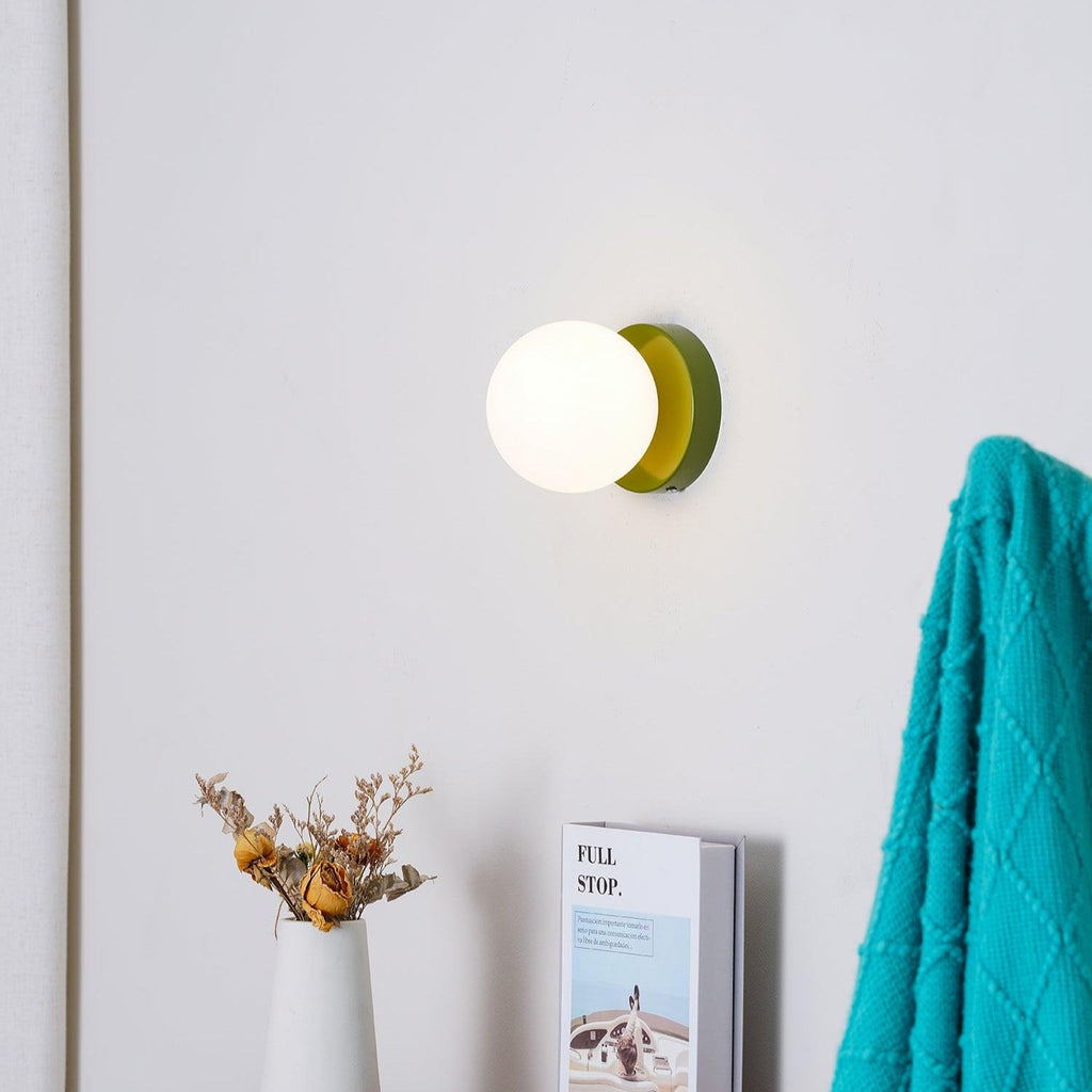 Compact Nuvol wall lamp casting a gentle glow on the wall