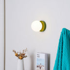Compact Nuvol wall lamp casting a gentle glow on the wall