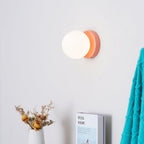 White glass globe Nuvol sconce lighting a cozy nook