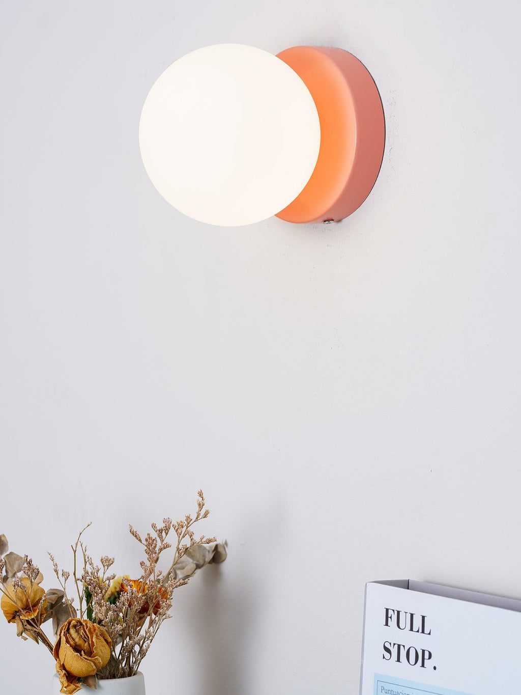 Compact Nuvol wall lamp glowing in a bright daytime interior
