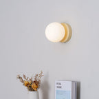 Nuvol wall lamp glowing beside a shelf of decor