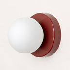 Nuvol wall lamp shown lit beside framed pictures