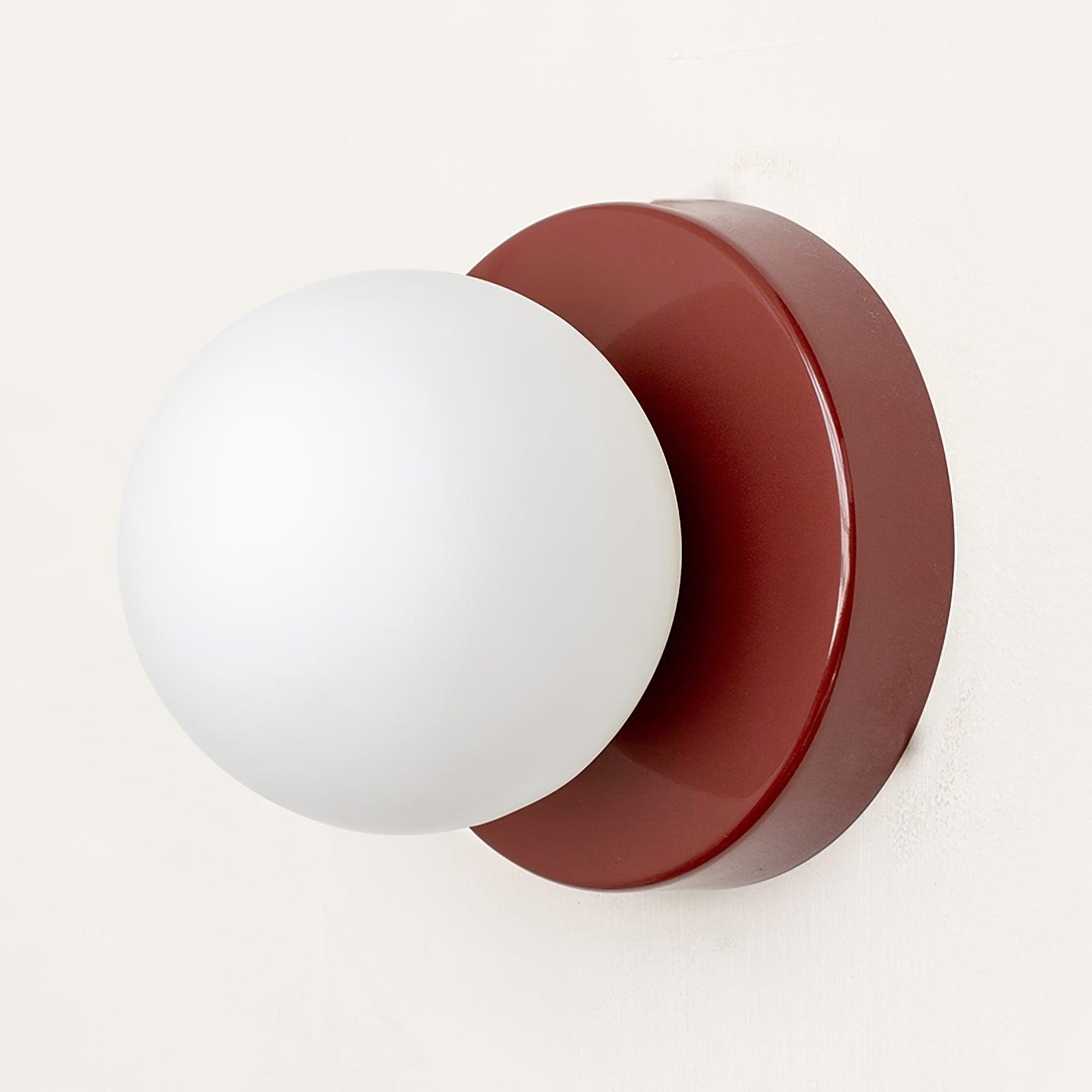 Nuvol wall lamp shown lit beside framed pictures