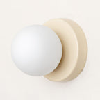 White glass globe Nuvol wall lamp on a colored metal base