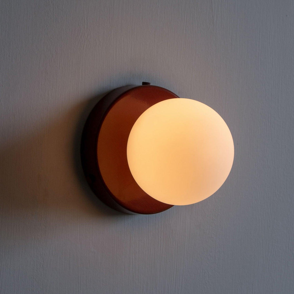 Nuvol compact glass sconce mounted at eye level on a wall