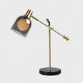 Clérachic brass table lamp shown centre-frame on a plain light grey background, its arm extended to one side.