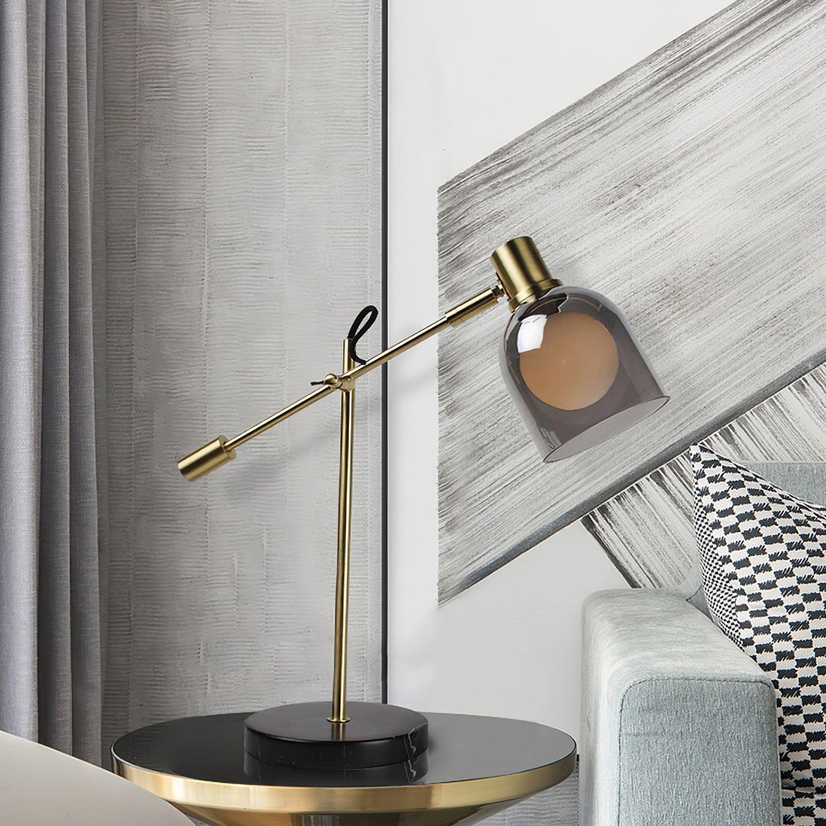 An angled grey and white wall panel backs the round gold-trimmed side table holding the Clérachic brass table lamp.