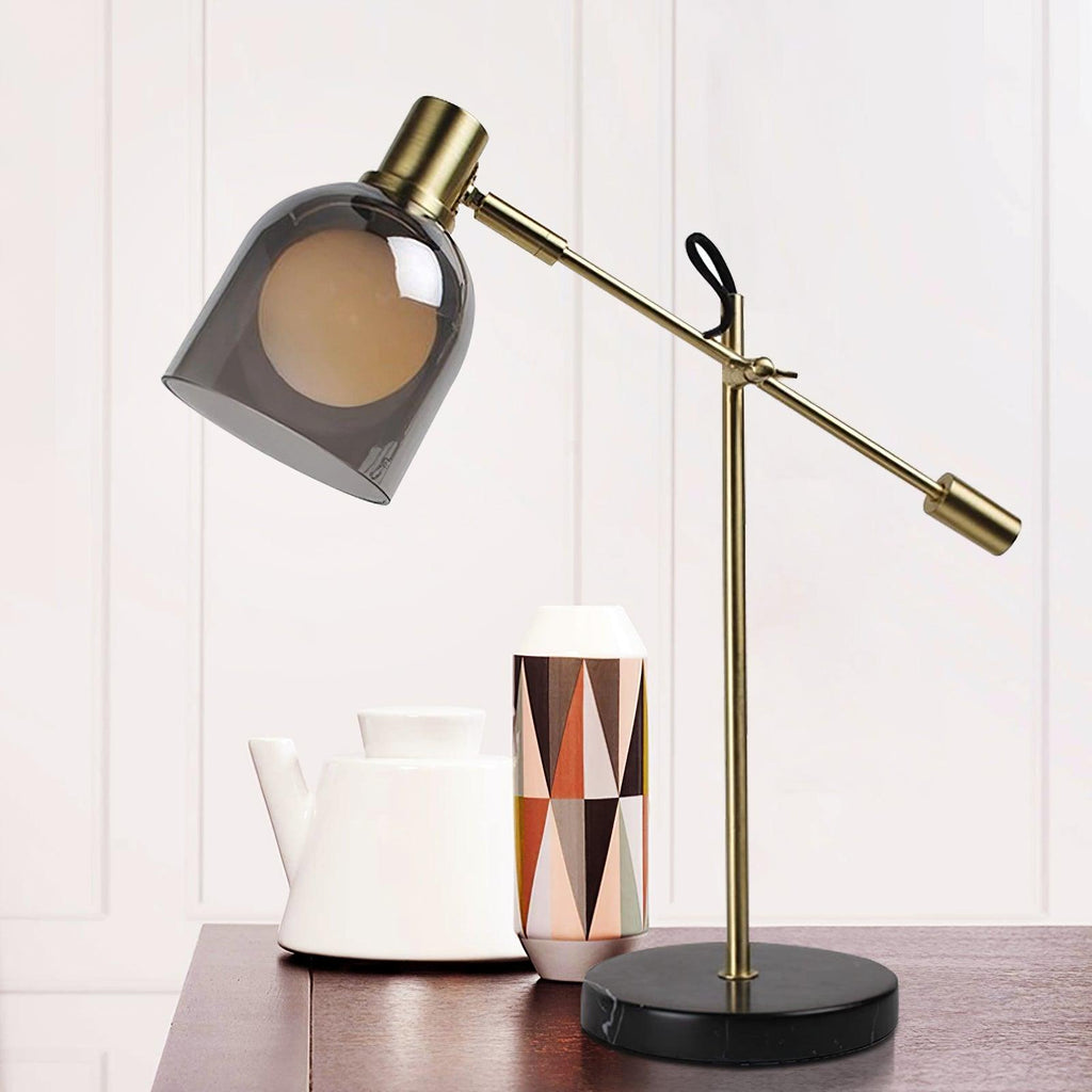 Clérachic brass table lamp on a dark wood table beside a white ceramic teapot and a geometric patterned vase.
