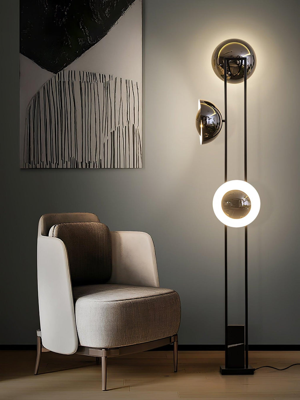 Clérachic floor lamp with its lower ring glowing, standing beside an abstract painting and a beige armchair.