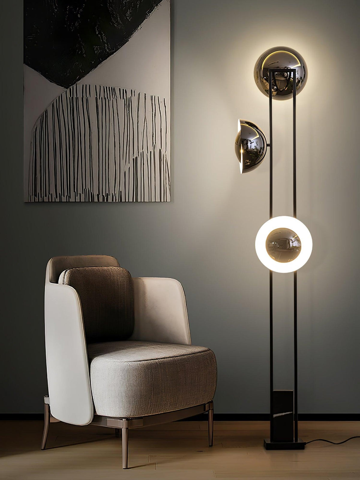 Clérachic floor lamp with its lower ring glowing, standing beside an abstract painting and a beige armchair.