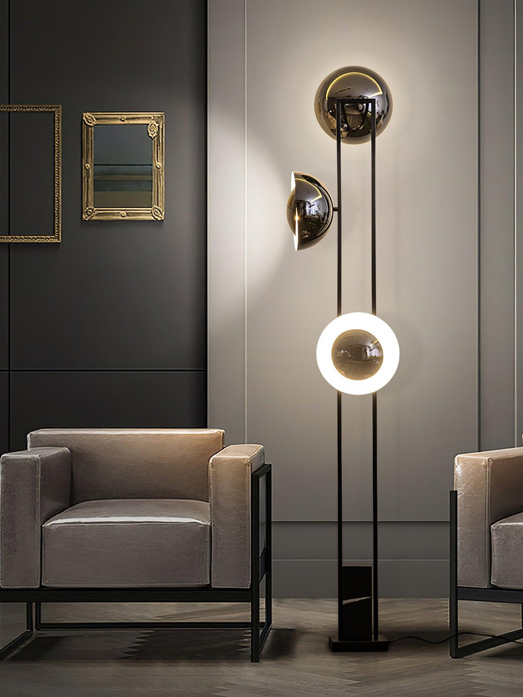 Clérachic floor lamp with its lower ring lit, framed between a gilt mirror and two matching grey armchairs.