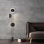 Upper heads of the Clérachic floor lamp shown close against a grey wall, beside a sofa draped with a woven throw.