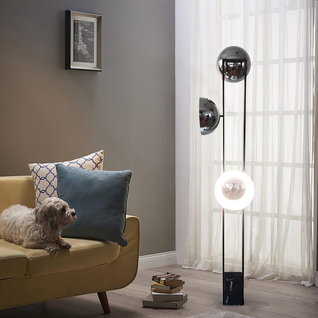 Lower half of the Clérachic floor lamp lit warm white beside a mustard sofa, with a small dog resting on the cushions.