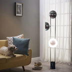 Lower half of the Clérachic floor lamp lit warm white beside a mustard sofa, with a small dog resting on the cushions.