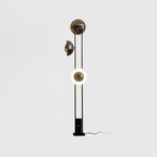 Clérachic floor lamp on a plain studio background, its lower ring lit warm white beneath two dome shades.