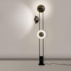 Clérachic floor lamp against a plain wall, its lower ring glowing warm white beneath two unlit dome shades.