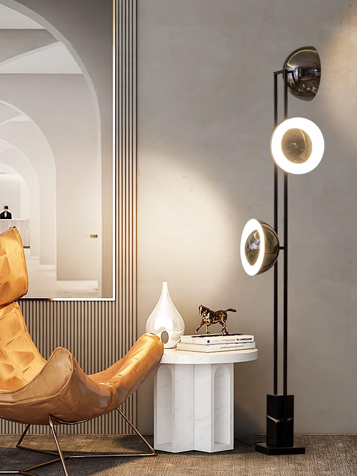 Clérachic floor lamp with all three heads lit, standing beside a tan leather chair and a marble pedestal table.