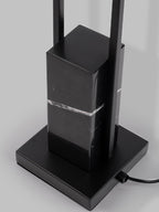 Close-up of the Clérachic floor lamp's black marble base and square foot, showing the mains cord and metal column.