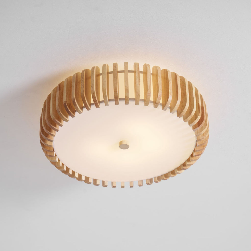 Seen from below in the studio, this Clérachic ceiling light glows lit, slats framing the diffuser.