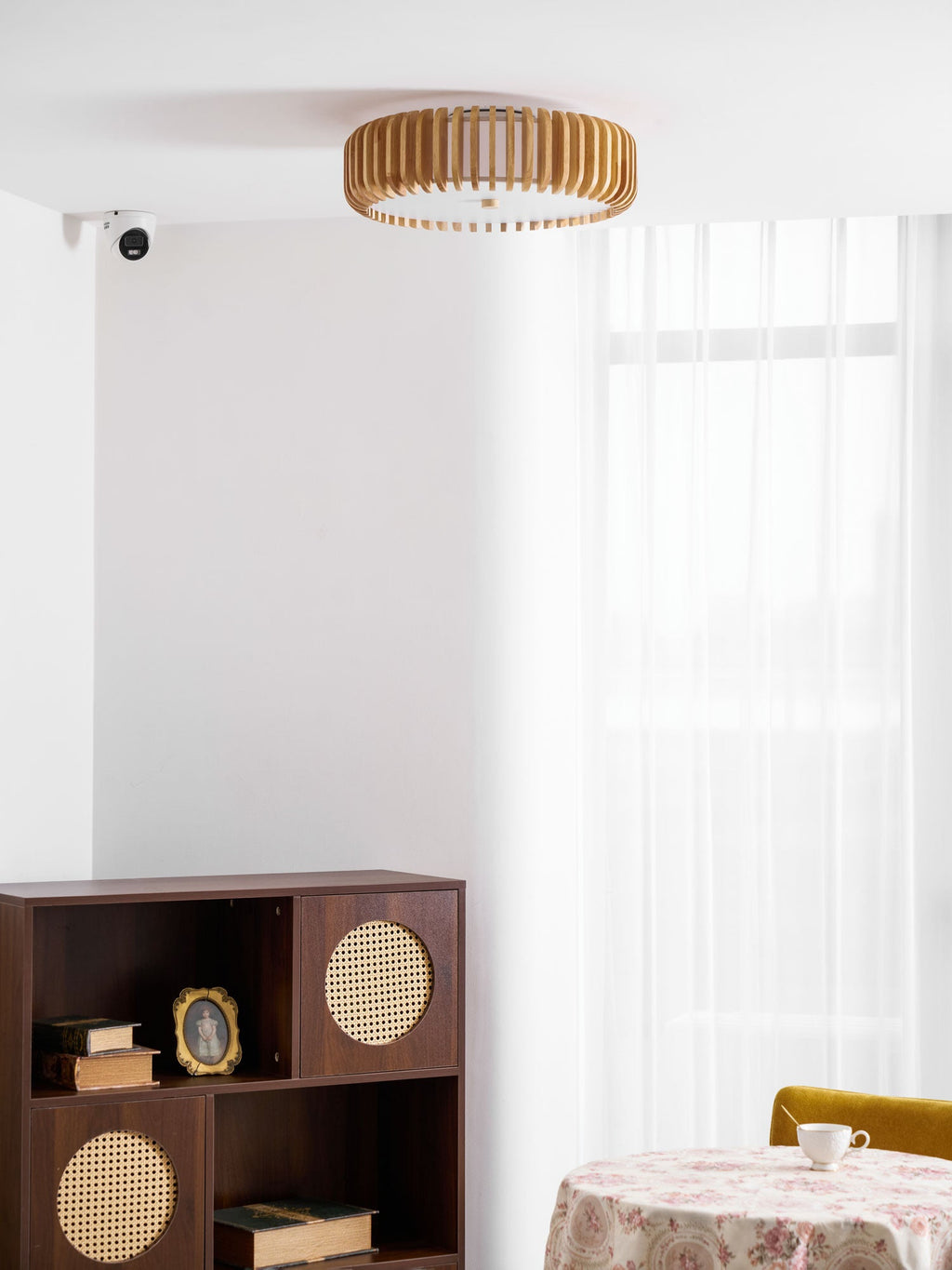 A wall sensor and a round dressed table sit below this Clérachic ceiling light in the corner.