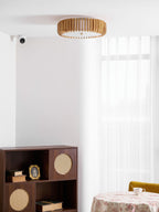 A wall sensor and a round dressed table sit below this Clérachic ceiling light in the corner.