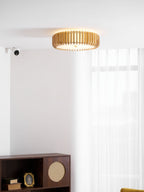 A dark cabinet with framed photos sits below this Clérachic ceiling light near a wall sensor.
