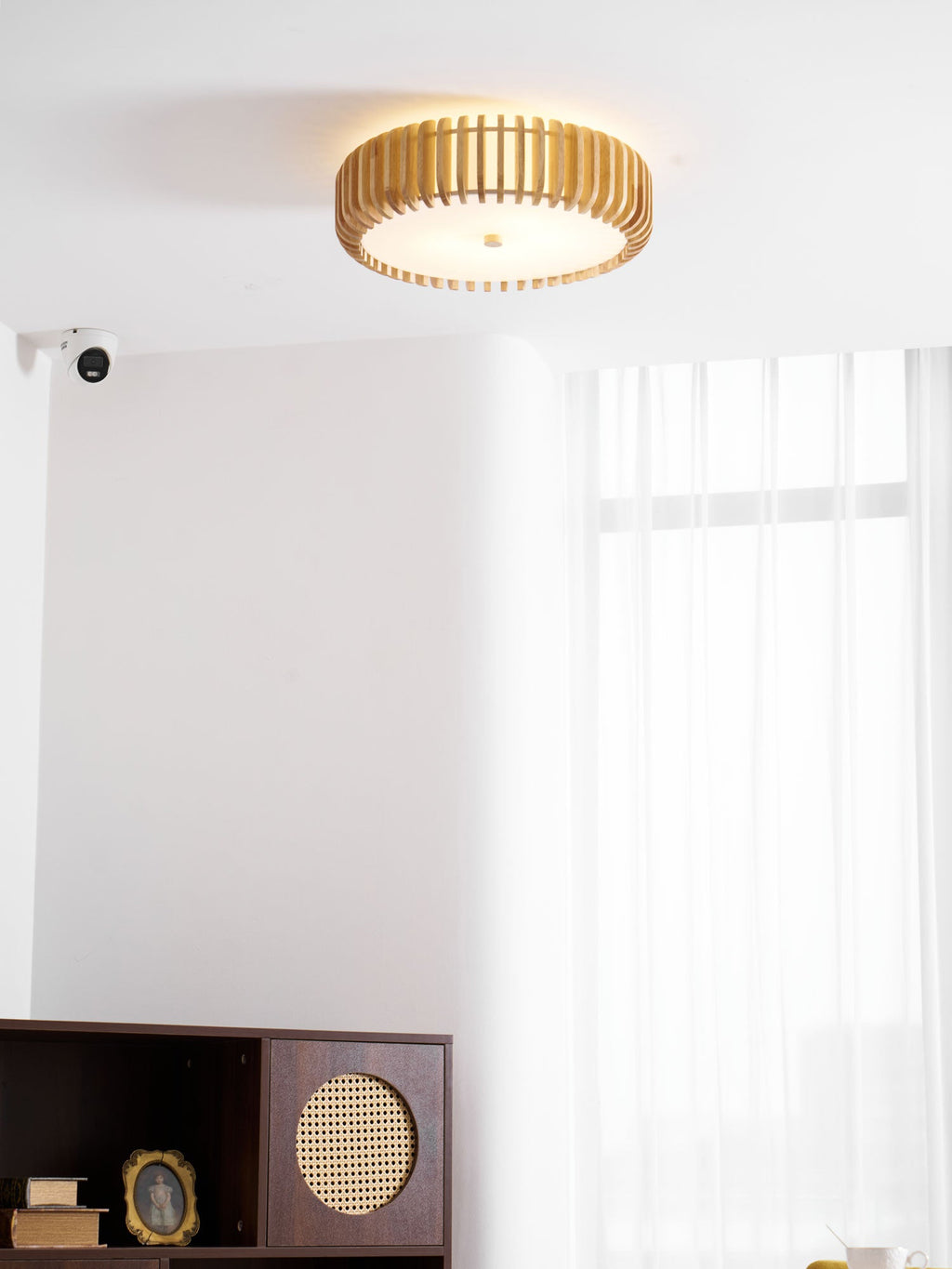 Lit in a room corner near a wall sensor and a dark cabinet, this Clérachic ceiling light glows warm.