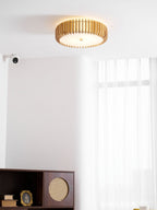 Lit in a room corner near a wall sensor and a dark cabinet, this Clérachic ceiling light glows warm.