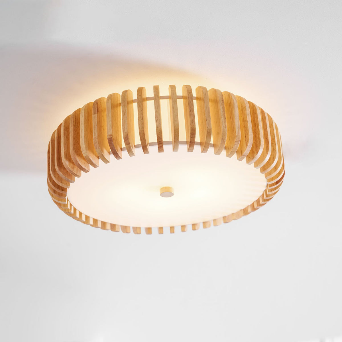Close view of this Clérachic ceiling light mounted near a wall, wood slats glowing warm.