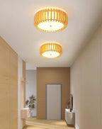 Two of this Clérachic ceiling light run lit along a hallway ceiling, leading to a wood door.