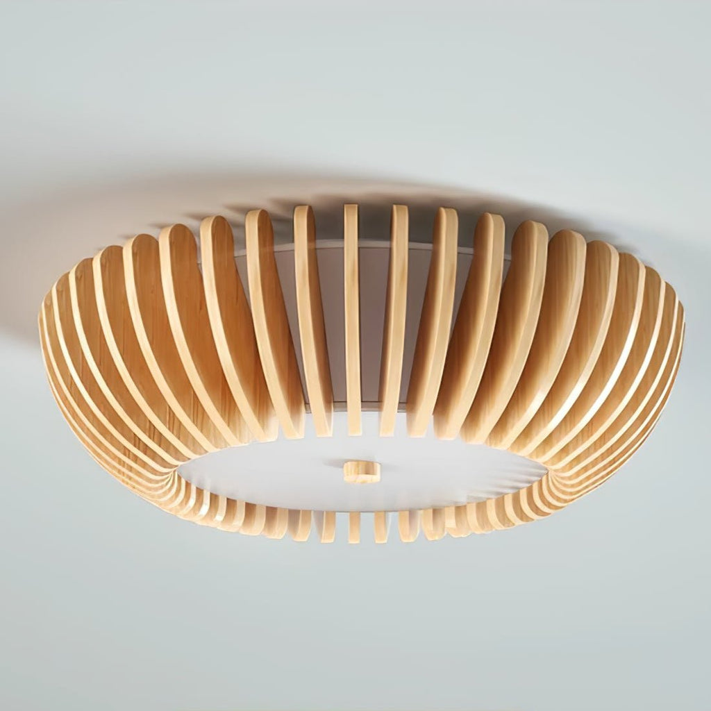 Close angled underside view of this Clérachic ceiling light lit, slats glowing against a pale blue backdrop.
