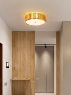 An entry hall with wood-panelled walls is lit overhead by this Clérachic ceiling light.