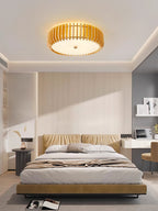A padded headboard and open shelving sit below this Clérachic ceiling light, lit, in a bedroom.