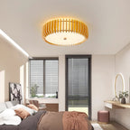 Lit above a bed with louvre blinds and a mirrored dresser, this Clérachic ceiling light warms the room.
