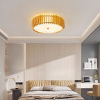 A bedroom with a padded headboard and desk nook, lit by this Clérachic ceiling light overhead.